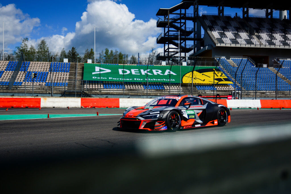 DTM-Rennfahrzeug auf der Rennstrecke des DEKRA Lausitzrings vor Tribüne und Start-Ziel-Bereich