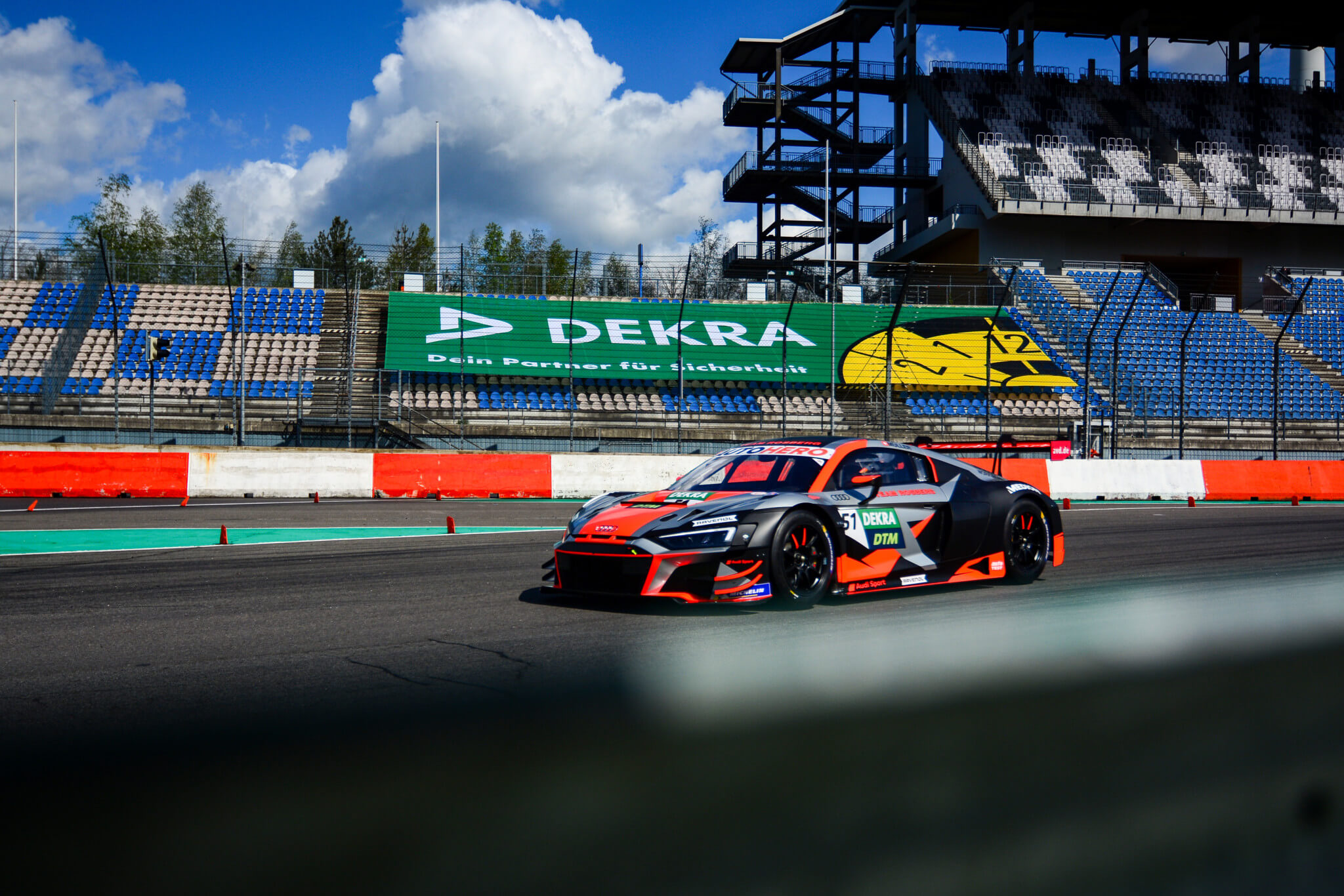 DTM-Rennfahrzeug auf der Rennstrecke des DEKRA Lausitzrings vor Tribüne und Start-Ziel-Bereich