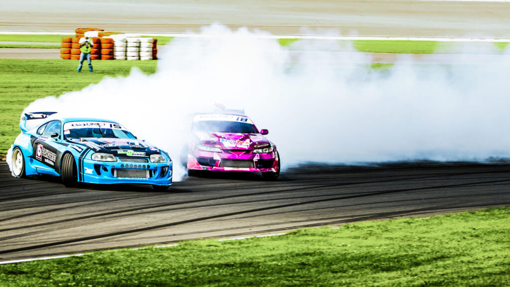 Zwei Fahrzeuge beim Driften im Rahmen der Driftshow des Reisbrennen auf dem DEKRA Lausitzring